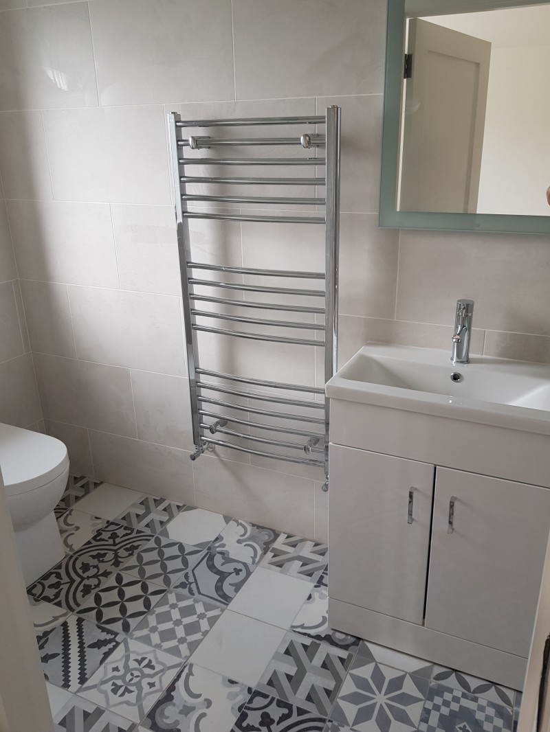 Chrome towel rail and vanity unit in a new bathroom installation in a Carrick-on-Shannon home by North West Tiles & Timber, Ireland